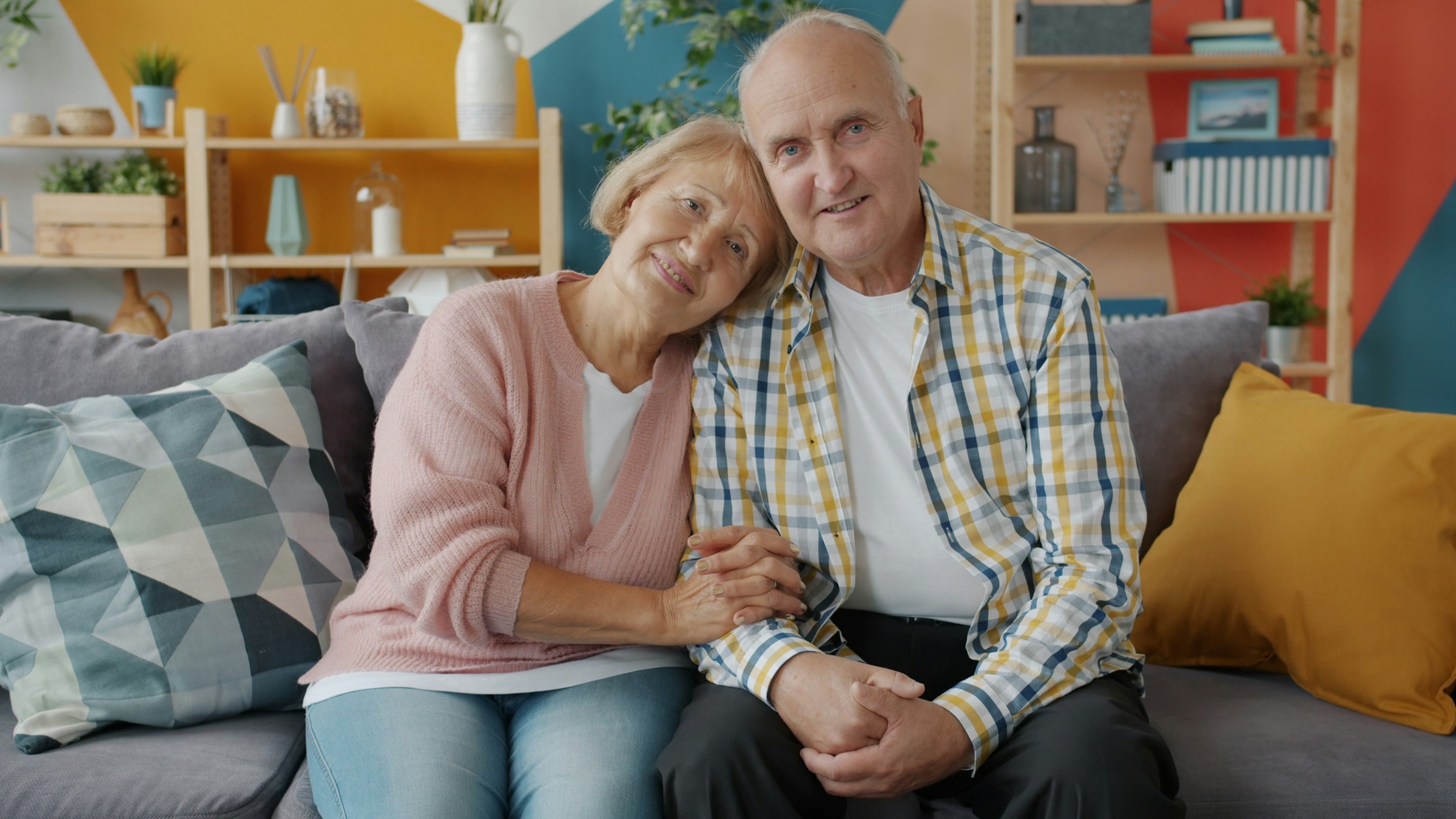 An older couple sitting together on a couch